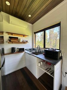 马拉库塔Ocean Breeze Tiny House - Ocean and Lake View的一个带水槽和窗户的小厨房