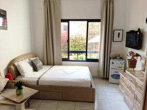迪拜Jumeirah Beach Villa的一间卧室设有一张床和一个大窗户