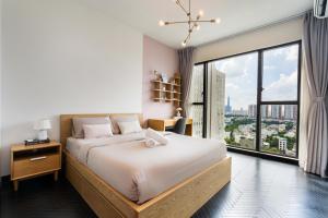 胡志明市DingD0ng Home FelizEnVista 5-star facilities的一间卧室设有一张大床和一个大窗户