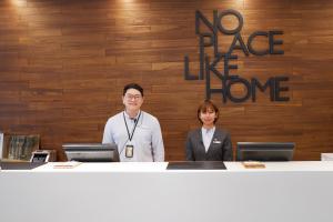 台北Home Hotel 的两个人站在柜台上,没有像家标那样的地方