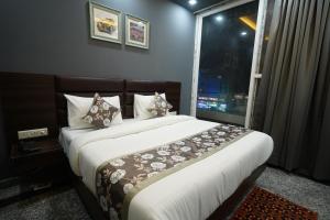 古尔冈Posh Garden Inn Artemis Hospital Road Gurgaon的一间卧室设有一张大床和窗户