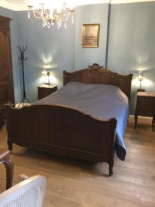 BaronvilleL'auberge的一间卧室配有一张大木床和蓝色的墙壁