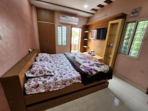 海得拉巴SCK Home Stay的一间卧室配有一张带花卉棉被的床