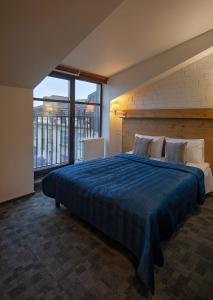 维尔纽斯Loft Inn SELF-CHECK IN的一间卧室配有一张带蓝色棉被的大床