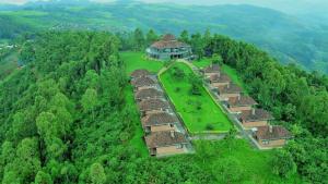 RwumbaNyungwe Hill View Hotel的森林中央村庄的空中景观