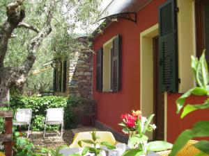 ChiusanicoAgriturismo La Vigna的一座红色和黄色的墙壁和椅子的房子