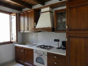 ChiusanicoAgriturismo La Vigna的厨房配有木制橱柜和炉灶烤箱。
