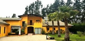 拉塞雷纳Casa Felice Altovalsol的一座黄色房子,前面有一棵棕榈树