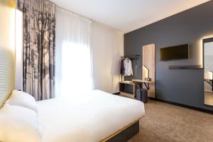 圣马克西姆B&B HOTEL Sainte-Maxime Golfe de Saint Tropez的一间酒店客房,配有一张床和一台电视