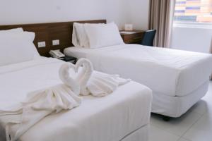 TagumCris Inn Tagum的两张位于酒店客房的床,配有毛巾