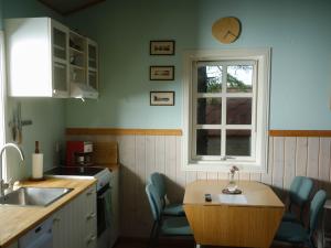 惠拉盖尔济Backyard Village的厨房配有桌椅和窗户。