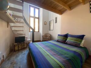 若西耶Magnifique appartement 8 couchages dans villa historique的一间卧室设有一张床和一个螺旋楼梯