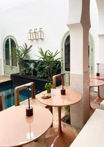 马拉喀什Riad Al Uzza的一间带2张桌子和游泳池的餐厅