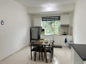 金宝Home Feel-Camellia Suites的厨房配有桌椅和冰箱。