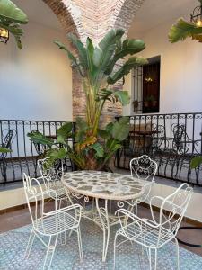 翁达拉Hotel 3* La Casona de las Flores的阳台的桌子和椅子以及植物