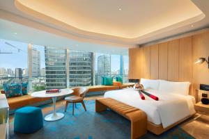 上海上海外滩W酒店的酒店客房设有一张大床和一张桌子。