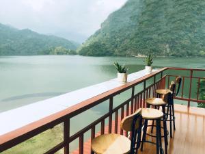 北市Nhà Nghỉ Sơn Lâm - Ba Bể lake Best view的阳台配有椅子,享有水景