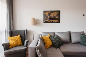 克拉科夫2-bedroom Apartment with garage in the city center的客厅配有灰色的沙发和黄色的枕头。