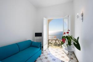 波西塔诺Il Barilotto的客厅设有蓝色沙发,享有海景