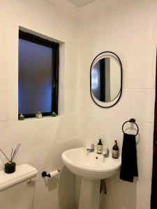 SandtonPeaceful Suburban Utopia的白色的浴室设有水槽和镜子