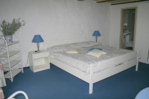 特湾祖姆阿尔滕施魏策尔酒店的一间卧室配有一张白色床和两盏灯。