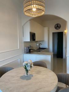 罗马GREEN HOUSE - PARCO TIRRENO的厨房配有一张桌子,上面放着花瓶