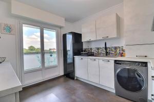 特鲁瓦Nid d'aigle - terrasse - vue ville - Mon Groom的厨房配有洗衣机和窗户。