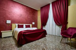 AltedoHOTEL PARADISO的一间卧室设有一张床和红色的墙壁