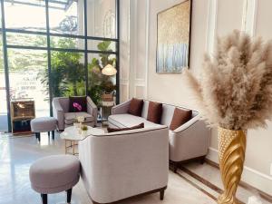胡志明市Hera Luxury Hotel的带沙发和植物花瓶的客厅