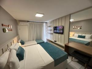 巴雷里尼亚斯Gran Lençois Flat的酒店客房配有两张床和一张书桌