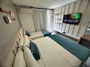 巴雷里尼亚斯Gran Lençois Flat的一间酒店客房,配有一张床和一台电视
