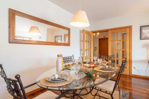 吉马良斯Homely Large Flat - Balcony的一间设有玻璃桌和椅子的用餐室