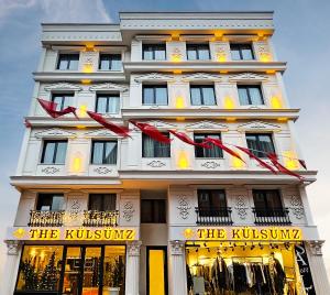 伊斯坦布尔The Külsümz Hotel的一座高大的白色建筑,上面有红色的弓
