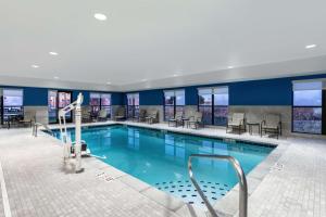 曼西曼西汉普顿酒店及套房的一座配有桌椅的酒店游泳池