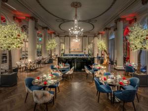 伦敦希尔顿华尔道夫酒店的一间带桌椅和吊灯的用餐室
