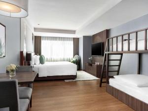 曼谷诺富特生活曼谷素坤逸传承的一间卧室配有两张双层床和一张书桌