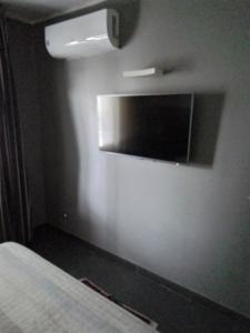 科森扎Uniclub House的卧室配有壁挂式平面电视。