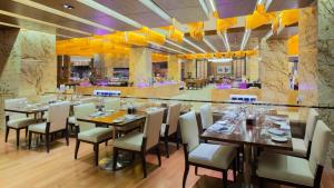 济南济南鲁能贵和洲际酒店的一间带木桌椅的餐厅和一间酒吧