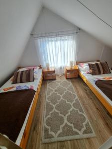 恰尔纳Domek pod Świerkami的带窗户的客房内的两张床