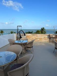 若昂佩索阿Flat Beira Mar de Tambaú apto 206的一个带桌椅的庭院和大海