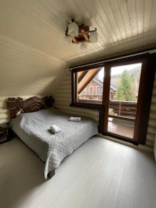 米戈韦Goral cottage in Migovo的一间卧室设有一张床和一个大窗户