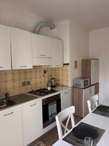 Casa Udine Charme 5 posti letto的厨房配有白色橱柜和炉灶烤箱。