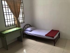 金宝Padusi Homestay的一间小卧室,配有一张小床和一个窗户