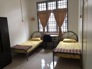金宝Padusi Homestay的客房设有两张床、一张桌子和一扇窗户。