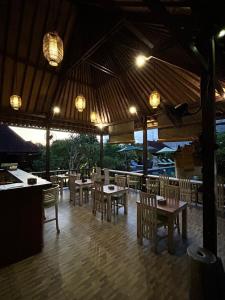 蓝梦岛Taman Sari Villa, Nusa Lembongan的餐厅设有木桌和椅子及灯