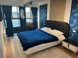苏恰瓦FancyLux Apartament的一间卧室配有一张带蓝色毯子的大床