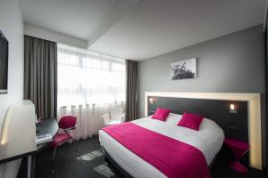 斯特拉斯堡Hôtel Restaurant Athena Spa的酒店客房配有一张带粉红色枕头的大床