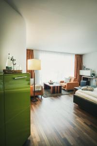 弗罗伊登施塔特Hotel Lauterbad的客厅配有绿色梳妆台和沙发