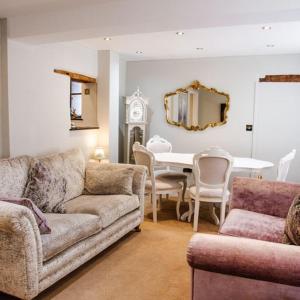 布由德利Whispering Place in the heart of Bewdley的带沙发、桌子和镜子的客厅