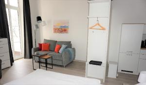 萨斯尼茨Villa Azur的客厅配有灰色沙发和橙色枕头。